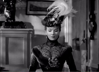 Movie still from “Kind Hearts and Coronets” (1949), directed by Robert Hamer – A woman in a black dress and a hat with feathers on her head; Close Up shot, Low angle
