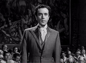 Movie still from “Kind Hearts and Coronets” (1949), directed by Robert Hamer – A black and white photo of a man in a suit and tie; Medium shot, Low angle