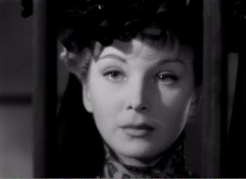 Movie still from “Kind Hearts and Coronets” (1949), directed by Robert Hamer – A black and white photo of a woman in a hat; Close Up shot, Over the shoulder angle