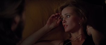 Movie still from “King Kong” (1976), directed by John Guillermin – A woman laying on a couch with her hand up to her face; Close Up shot, Overhead angle