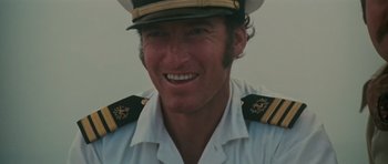 Movie still from “King Kong” (1976), directed by John Guillermin – A person wearing a uniform; Close Up shot, Low angle