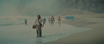 Movie still from “King Kong” (1976), directed by John Guillermin – A group of people walking along the beach; Wide shot, High angle