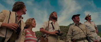 Movie still from “King Kong” (1976), directed by John Guillermin – A group of people standing on top of a hill; Medium shot, Low angle