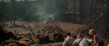 Movie still from “King Kong” (1976), directed by John Guillermin – A group of people standing on top of a dirt field; Extreme Wide shot, High angle