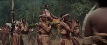 Movie still from “King Kong” (1976), directed by John Guillermin – A group of people in native dress in a forest; Wide shot, Low angle