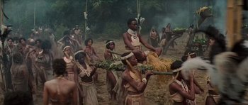 Movie still from “King Kong” (1976), directed by John Guillermin – A group of people standing in a forest; Wide shot, High angle