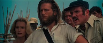 Movie still from “King Kong” (1976), directed by John Guillermin – A man with long hair and a long beard; Close Up shot, Low angle