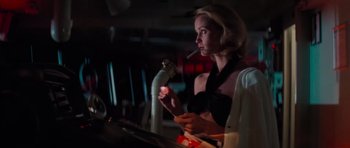 Movie still from “King Kong” (1976), directed by John Guillermin – A woman is smoking a cigarette in a dark room; Medium shot, Low angle