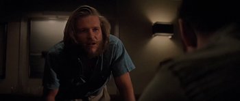 Movie still from “King Kong” (1976), directed by John Guillermin – A man with long hair and a goatee looks at the camera; Close Up shot, Low angle