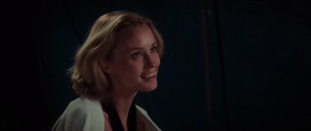 Movie still from “King Kong” (1976), directed by John Guillermin – A beautiful blond woman smiling for the camera; Close Up shot, Over the shoulder angle