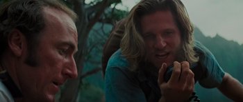 Movie still from “King Kong” (1976), directed by John Guillermin – A man talking on a cell phone next to another man; Close Up shot, Over the shoulder angle
