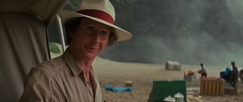 Movie still from “King Kong” (1976), directed by John Guillermin – A man wearing a hat standing in the sand; Close Up shot, Over the shoulder angle