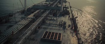 Movie still from “King Kong” (1976), directed by John Guillermin – An aerial view of an oil rig in the middle of the ocean; Extreme Wide shot, Overhead angle
