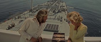 Movie still from “King Kong” (1976), directed by John Guillermin – Two people are playing backgammon on a ship; Medium shot, High angle