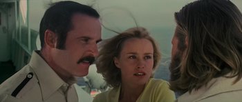 Movie still from “King Kong” (1976), directed by John Guillermin – A group of people standing next to each other in a room; Close Up shot, Low angle