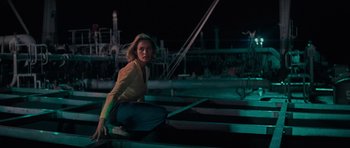 Movie still from “King Kong” (1976), directed by John Guillermin – A woman crouching down on some steps at night; Medium shot, Low angle