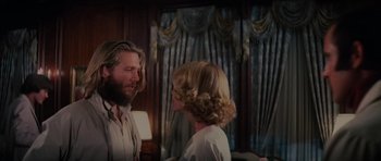 Movie still from “King Kong” (1976), directed by John Guillermin – A man and a woman standing next to each other in a room; Medium shot, Over the shoulder angle