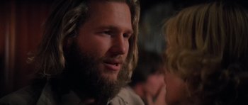 Movie still from “King Kong” (1976), directed by John Guillermin – A man with a long beard is talking to a woman; Close Up shot, Over the shoulder angle