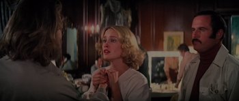 Movie still from “King Kong” (1976), directed by John Guillermin – A woman in a white shirt is holding her hands together; Close Up shot, Over the shoulder angle