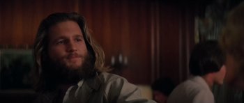 Movie still from “King Kong” (1976), directed by John Guillermin – A man with long hair and a long beard; Close Up shot, Over the shoulder angle