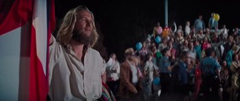 Movie still from “King Kong” (1976), directed by John Guillermin – A man with long hair and a long beard standing in front of a group of people; Medium shot, Low angle
