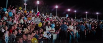 Movie still from “King Kong” (1976), directed by John Guillermin – A crowd of people sitting and standing in front of a stadium; Wide shot, High angle