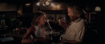 Movie still from “King Kong” (1976), directed by John Guillermin – A man and a woman sitting at a table with drinks; Medium shot, Over the shoulder angle