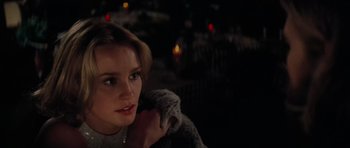 Movie still from “King Kong” (1976), directed by John Guillermin – A woman sitting in front of candles in a dark room; Close Up shot, Over the shoulder angle