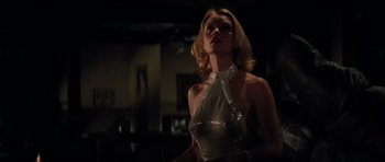 Movie still from “King Kong” (1976), directed by John Guillermin – A woman in a silver dress looking up at the ceiling; Medium shot, Low angle