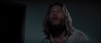 Movie still from “King Kong” (1976), directed by John Guillermin – A man with long hair and a beard looking up; Close Up shot, Low angle