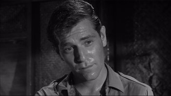 Movie still from “King Rat” (1965), directed by Bryan Forbes – A black and white photo of a man with wet hair; Close Up shot, High angle