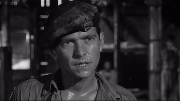 Movie still from “King Rat” (1965), directed by Bryan Forbes – A black and white photo of a man wearing a hat; Close Up shot, Low angle