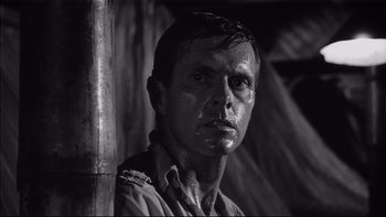 Movie still from “King Rat” (1965), directed by Bryan Forbes – Black and white photograph of a man with a dirty face; Close Up shot, Low angle
