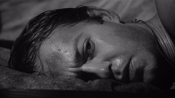 Movie still from “King Rat” (1965), directed by Bryan Forbes – A person laying on the ground; Close Up shot, High angle