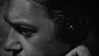 Movie still from “King Rat” (1965), directed by Bryan Forbes – A woman's face with water droplets on it; Extreme Close Up shot, Low angle