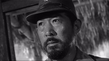 Movie still from “King Rat” (1965), directed by Bryan Forbes – A person wearing a hat; Close Up shot, Low angle