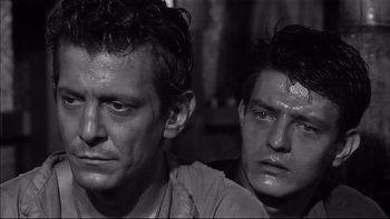 Movie still from “King Rat” (1965), directed by Bryan Forbes – A black - and - white photo of two men looking at the camera; Close Up shot, High angle