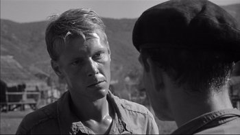 Movie still from “King Rat” (1965), directed by Bryan Forbes – A man in a military uniform talking to another man; Close Up shot, Over the shoulder angle