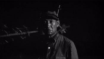Movie still from “King Rat” (1965), directed by Bryan Forbes – A black and white photo of a man wearing a hat; Close Up shot, Low angle