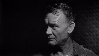 Movie still from “King Rat” (1965), directed by Bryan Forbes – An older man with wet hair looking into the distance; Close Up shot, Over the shoulder angle