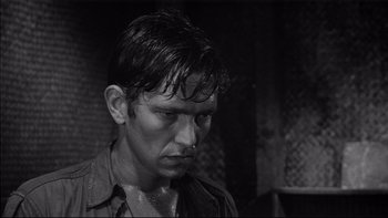 Movie still from “King Rat” (1965), directed by Bryan Forbes – Black and white photograph of a man with wet hair; Close Up shot, Low angle