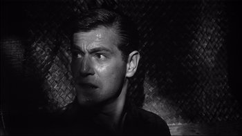 Movie still from “King Rat” (1965), directed by Bryan Forbes – Black and white photograph of a man looking up; Close Up shot, Low angle