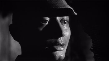 Movie still from “King Rat” (1965), directed by Bryan Forbes – A black and white photo of a man's face; Close Up shot, Low angle