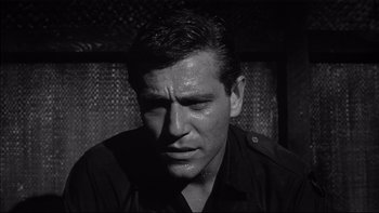 Movie still from “King Rat” (1965), directed by Bryan Forbes – Black and white photograph of a man with a sad look on his face; Close Up shot, Low angle
