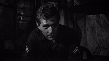 Movie still from “King Rat” (1965), directed by Bryan Forbes – Black and white photograph of a man in military uniform; Close Up shot, Over the shoulder angle