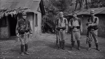 Movie still from “King Rat” (1965), directed by Bryan Forbes – A black and white photo of a group of men in uniform; Wide shot, Low angle