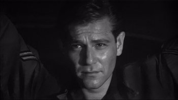 Movie still from “King Rat” (1965), directed by Bryan Forbes – Black and white photograph of a man in a car; Close Up shot, Low angle