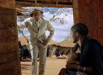 Movie still from “King Solomon's Mines” (1950), directed by Andrew Marton – A man wearing a suit and hat standing next to a woman; Medium shot, Over the shoulder angle