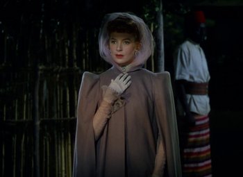 Movie still from “King Solomon's Mines” (1950), directed by Andrew Marton – A woman wearing a cape and a veil; Medium shot, Over the shoulder angle