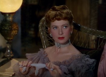 Movie still from “King Solomon's Mines” (1950), directed by Andrew Marton – A woman sitting in a chair holding a pair of scissors in her hands; Close Up shot, Over the shoulder angle